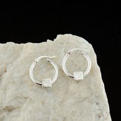 This pretty pair of Cube Charm Sterling Silver Hoops are handcrafted for you with great care from high-quality 925 Sterling Silver hand-hammered charms. The earrings are easy to put on and perfect for everyday wear. MATERIALS AND SIZE  ◆ Metal - 925 Sterling Silver ◆ Hoop Size is 15 mm / 0.59 inches from the top to bottom  GIFT AND PACKAGING ◆ All jewelry is packed beautifully in a branded gift box. ◆ If the item is intended as a gift, please pick the gift option at the checkout. A free personal Handmade Sterling Silver Huggie Earrings For Everyday, Handmade Sterling Silver Huggie Earrings, Handmade Minimalist Small Hoop Wrap Earrings, Everyday Handmade Huggie Earrings, Minimalist Handmade Hoop Wrap Earrings, Handmade Minimalist Small Hoop Earrings, Modern Handmade Huggie Earrings For Everyday, Handmade Minimalist Small Hoop Huggie Earrings, Handmade Minimalist Huggie Hoop Earrings