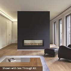 an empty living room with a fireplace and two black chairs in front of the fire place