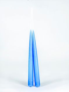 two blue candles with white sticks sticking out of them