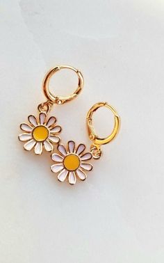 "*Dainty, fun and charming daisy charm huggie hoop earrings! Awesome 90s style throwback! *Layer with other hoops/earrings or wear on its own. *White, yellow and gold enamel daisy flower charm gold plated over zinc alloy- nickel free and lead free *18k gold plated 12mm leverback huggie hoops *Please remove when showering, swimming, sleeping, sweating, etc to preserve the shine and color of the charms! *Quality, small batch, unique, chic Please check out shop policies or message me about question Cute Hypoallergenic Huggie Earrings, Cute Hypoallergenic Hoop Earrings, Cute Gold Summer Jewelry, Cute Huggie Hoop Earrings, Cute Gold Jewelry With Flower Charm, Trendy Gold Hoop Earrings With Flower Charm, Cute Gold Flower Earrings For Spring, Trendy Gold Flower Shaped Hoop Earrings, Cute Nickel-free Hoop Jewelry