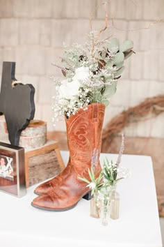 a cowboy boot with flowers in it sitting on a table