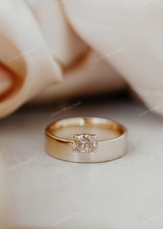 an engagement ring sitting on top of a white cloth