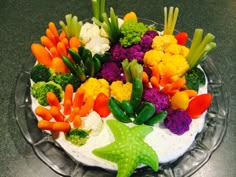 there is a cake decorated with vegetables on the top and starfish decoration at the bottom