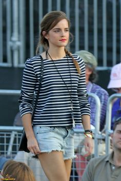 a woman walking down the street in denim shorts