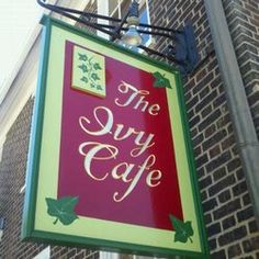 the sign for the restaurant is hanging on the building's front door and it says, the sky cafe