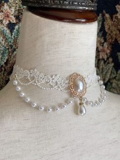 This beautiful Rococo & Regency inspired choker necklace is dripping in faux pearls, and white floral lace; making it the perfect historical accessory to tie-together an outfit for a ball or promenade! Sizing: One SizeNeck Circumference 12-16 Inches / 30.5-40.5 CentimetersAdjustable claw clasp 1905 Dresses, Rococo Inspired Outfits, Pearl Choker Necklace Design, Rococo Necklace, Rococo Outfit, Rococo Accessories, Floral Necklaces, Rococo Jewelry, Regency Accessories