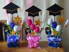 three vases filled with flowers and graduation decorations