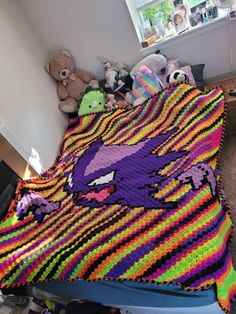 there is a colorful crocheted blanket on the bed