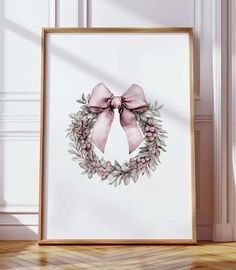 a pink bow is hanging on the wall next to a white framed poster with flowers and leaves