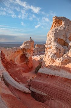 a person standing on top of a large rock formation in the middle of a desert