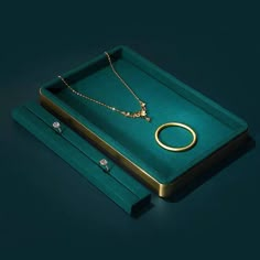 a green box with two necklaces and a ring on it