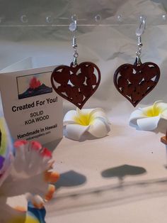 two heart shaped wooden earrings on display in front of a card with the words created for you