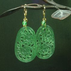 "What fantastic art piece of Jewelry.  Gorgeous artistic pierced vintage green jades in oval shaped.  They're elegantly covered in detail flowers on the both sides.  I added green jades are dangling on side.  They are connect to 16k gold filled leverback hooks.  They are earrings fall of stunning and mysterious and waiting for you to pick them up. Jade - a gemstone of unique symbolic energy, and unique in the myths that surround it.  With its beauty and wide-ranging expressiveness, jade has held Gold Jade Wedding Earrings, Handmade Traditional Jade Earrings, Traditional Handmade Jade Earrings, Elegant Carved Round Earrings, Elegant Round Carved Earrings, Elegant Carved Drop Earrings, Elegant Flower Shaped Jade Jewelry, Exquisite Green Teardrop Earrings, Jade Drop Earrings For Anniversary