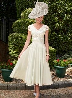 a woman wearing a white dress and hat