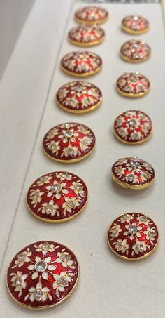 red and gold buttons with white flowers on them