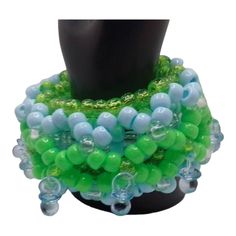 Blue and green are the star colors of this Shaker Kandi 3d cuff.  There are 10 mini blue pacifiers around this is kandi bracelet.  You just shake it to drive the no e believers crazy.   Baby blue, neon green, clear, and sparkle green. Will mail out first clasd. Adjustable Blue-green Beaded Jewelry, Green Round Beads Bracelets For Party, Handmade Blue Beaded Plastic Bracelets, Handmade Adjustable Blue-green Jewelry, Green Round Beaded Bracelets For Party, Green Beaded Bracelets With Large Beads As Gift, Blue Plastic Party Jewelry, Green Plastic Bracelet Jewelry, Green Stretch Bracelet With Colorful Beads For Party