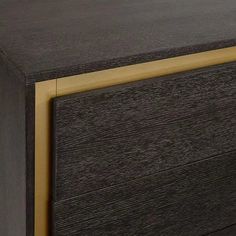 a close up of a black and gold dresser with wood grained finish on the drawers