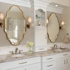 a bathroom with double sinks and two mirrors on the wall next to eachother