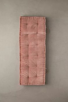 a pink cushion hanging on the wall