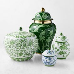 three green and white vases sitting next to each other