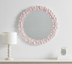 a round mirror on the wall above a dresser