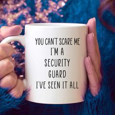 a woman holding a coffee mug that says you can't scare me i'm a security guard i've seen it all