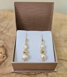 About this product: Our Freshwater Pearl Earrings are a dainty, opulent accessory that dangles lightly from your ears. Pearls are used as the main centerpiece to this lovely set. It is then accented by 14k Filigree Beads and 925 Gold Earring wires. We've made these earrings with lightweight and allergen-friendly materials, so you can have your own beauty naturally accented without sacrificing any comfort. This product will come in the displayed gift box along with a polishing cloth.   What we lo Elegant Gold Wire Wrapped Jewelry, Elegant Formal Wire Wrapped Jewelry, Elegant Pearl Jewelry With Wire Wrapped Detail, Gold Wire Wrapped Earrings For Formal Occasions, Elegant Wire Wrapped Earrings For Formal Occasions, 14k Gold-filled Beaded Drop Earrings, Formal Gold Wire Wrapped Earrings, Elegant Round Wire Wrapped Jewelry, Elegant Wire-wrapped Yellow Gold Pearl Earrings