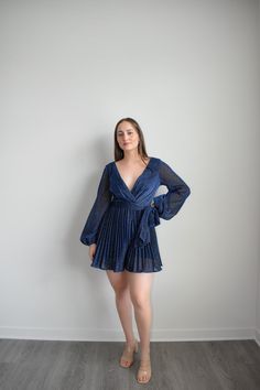 Navy Dress Romper with sparkling belt and long sleeves to dazzle at any formal event. Featuring an adjustable belt and a plunging v-neckline, you can elevate your look with sky-high heels or simply make it a more relaxed ensemble for at-home soirées. Crafted from a lightweight Polyester, this Navy Dress Romper is the epitome of grace and sophistication. Size guide: The First Model is 5'6" and wearing size Small. The Second model is wearing a size small Glamorous Long Sleeve V-neck Dress For Date Night, Glamorous Spring V-neck Party Dress, Glamorous Spring Evening V-neck Dress, Cocktail V-neck Belted Mini Dress, Glamorous Long Sleeve V-neck Party Dress, Elegant V-neck Belted Dress For Evening, Formal V-neck Belted Dress, Formal Belted V-neck Dress, Elegant Belted Mini Dress For Evening