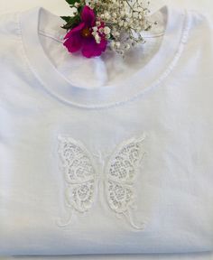 "Embroidered with a beautiful cutwork Butterfly with the cut-outs within the wings.  This is an intricate delicate design which has required great skill to create.   The cutwork design adds visual interest and uniqueness to the T shirt.  An exquisite elegant design looking stunning on white, grey, navy or black Unisex T shirts. This can be done on a Ladies \"V\" neck as well.  Just message me if you want this.   Perfect as a gift or to treat yourself for parties and everyday use, evenings out or Crew Neck Tops With Machine Embroidery For Gifts, White Butterfly-shaped Top For Summer, White Butterfly T-shirt For Summer, White Butterfly T-shirt For Spring, Machine Embroidered Short Sleeve T-shirt As Gift, Machine Embroidered Short Sleeve T-shirt For Gift, Embroidered Short Sleeve T-shirt For Gift, White T-shirt With Machine Embroidery As Gift, White T-shirt With Machine Embroidery For Gift