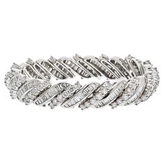 This platinum midcentury round and baguette cut diamond bracelet is a truly unique and exquisite piece of jewelry. The combination of round and baguette cut diamonds creates a mesmerizing sparkle and shine that is truly remarkable. This bracelet is also crafted in platinum, a metal that is extremely durable and highly resistant to tarnishing, so you can be sure that it will last a lifetime. Diamond Carat Weight: 16.50cttw. Quality: F-G color, VS-SI clarity. Wrist size 6 inches. Modern Bracelets, Baguette Cut Diamond, Expensive Jewelry, Baguette Cut, Sparkle And Shine, Diamond Carat, A Metal, Diamond Bracelet, 6 Inches