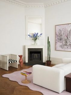 a living room filled with furniture and a fire place next to a painting on the wall