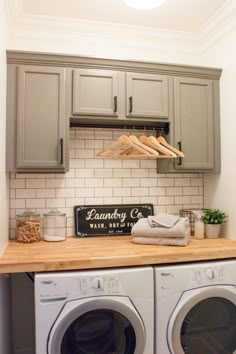 a washer and dryer in a laundry room with wooden counter tops on the side