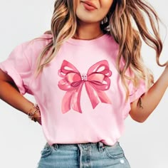 Embrace elegance and flirtatious charm with our captivating pink bow shirt, a delightful addition to your coquette-inspired wardrobe! 🌸👚 This shirt embodies the essence of femininity and playfulness, perfect for those who adore a touch of chic sophistication with a hint of flirtation. 🌷 The darling pink hue complements the shirt's design, accentuating the focal point--an exquisitely crafted oversized bow adorning the neckline or sleeves, adding a whimsical and flirtatious allure to your ensem Boho Ribbon, Hipster Tshirts, Bow Shirt, Ribbon Shirt, Bow Shirts, Coquette Style, Coquette Pink, Feminine Fashion, Girls Bows