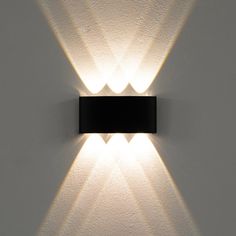 a wall mounted light on the side of a white wall with two lights in it