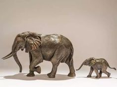 an adult and baby elephant walking next to each other in front of a white background