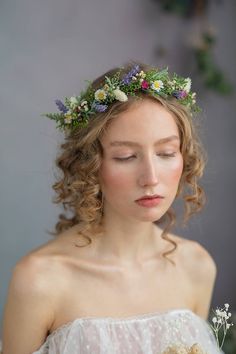 a woman wearing a flower crown with flowers in her hair