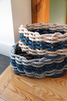 three woven baskets sitting on top of a wooden table