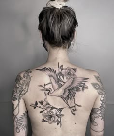 the back of a woman's body with tattoos on her upper and lower half