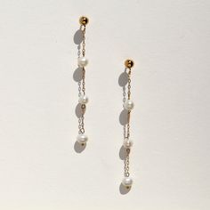 Absolutely stunning on, these tiny triple tiered freshwater pearls float on delicate 14k gold filled chain. The 3mm wide pearls set along a whisper of chain, create a super chic minimal look that will offset a harder masculine outfit, and work equally well with feminine, bridal looks.  The ball ear post and backing are both 14k gold filled. 14k gold filled metal does not flake off and contains significantly more gold than regular 'gold plated' jewelry. It is considered second in quality to solid Cheap Minimalist Pearl Earrings With Pearl Charm, Dainty Pearl White 14k Gold Filled Pearl Earrings, Dainty Pearl Drop Linear Earrings, Delicate 14k Gold Filled Earrings With Pearl Chain, Delicate Pearl Chain Dangle Earrings, Delicate Pearl Earrings With Dangling Beads Gift, Dainty Yellow Gold Pearl Drop Linear Earrings, Dainty Yellow Gold Linear Earrings With Pearl Drop, Delicate Pearl Chain Earrings For Everyday