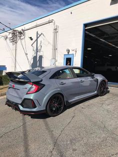 a grey car parked in front of a building