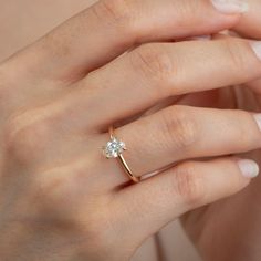 a woman's hand with a diamond ring on it