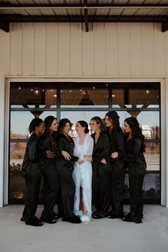 a group of women standing next to each other in front of a building with glass doors