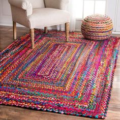 a colorful rug in a living room next to a chair