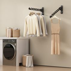 clothes hanging on hooks next to washing machine and dryer