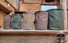 four different colored bags sitting on top of a wooden shelf