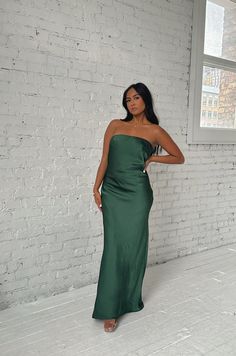 This Emerald Green Maxi Dress will make you feel elegant and special. Crafted from luxuriously smooth satin silky, the dress features a strapless silhouette with a cowl back and a waisted tie. The long length flatters any figure and makes this dress perfect for a formal occasion. emerald green strapless dramatic cowl back back bow tie relaxed fit long length 100% polyester model is wearing a small Satin Backless Midi Dress For Prom, Satin Floor-length Slip Dress For Date Night, Floor-length Satin Slip Dress For Date Night, Elegant Green Slip Dress With Straight Neckline, Chic Silk Backless Prom Dress, Satin Long Evening Dress For Night Out, Silk Backless Long Dress For Party, Satin Dress For Date Night With Straight Neckline, Straight Neckline Satin Dress For Date Night