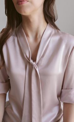 A forever elegant classic. This versatile bow blouse is a dynamic beauty: think Madame President to romantic rendezvous – she can do it all. Wear the neck tie on, off, half-way, or tie it into a bow for a look of class and sass. Removable neck bow to switch up your look. A classy v-neck cut. Concealed button placket for an elegant finish. 100% MULBERRY CHARMEUSE SILK – Washable Formal Tops For Women Classy, Formal Tops For Women, Silk Blouse Outfit, Cotton Tops Designs, Classy Blouses, Stylish Tops For Women, Style Guru, Neck Bow, Silk Bow