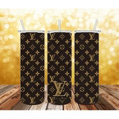 three black and gold louis vuitton lighters on wooden table with lights in the background