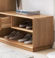 there is a shelf with shoes on it and a book in the bottom drawer next to them