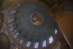 the inside of an old church with stained glass windows and a domed ceiling in it